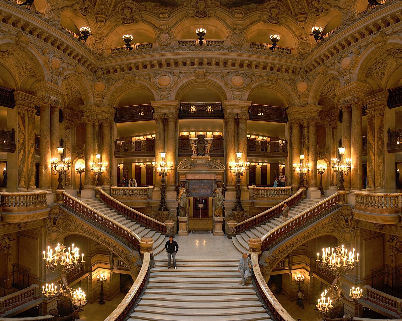 Grand escalier de marbre, double volée, balustrades ouvragées et rampes dorées